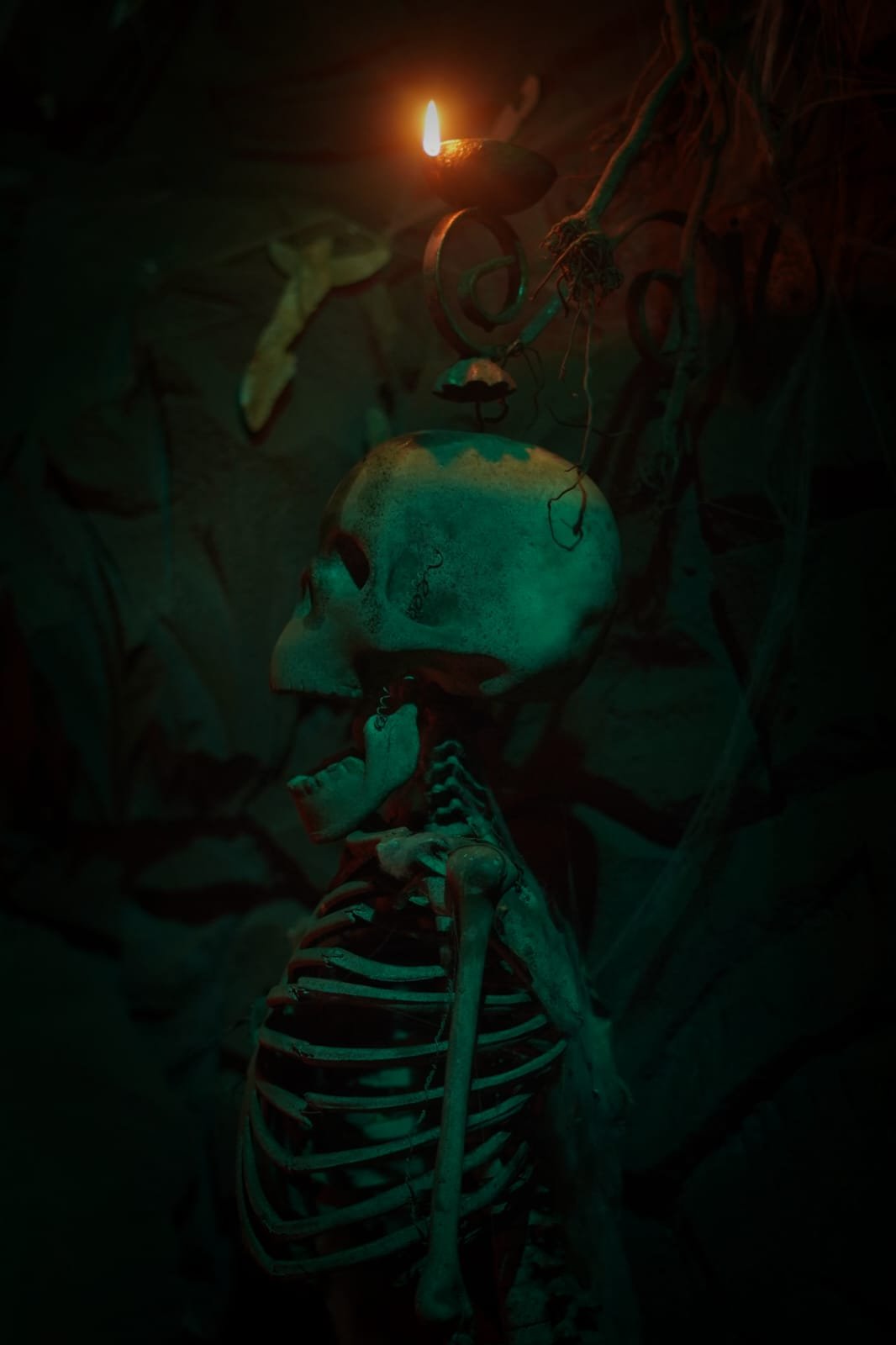 Skeleton with candle inside ancient ruins